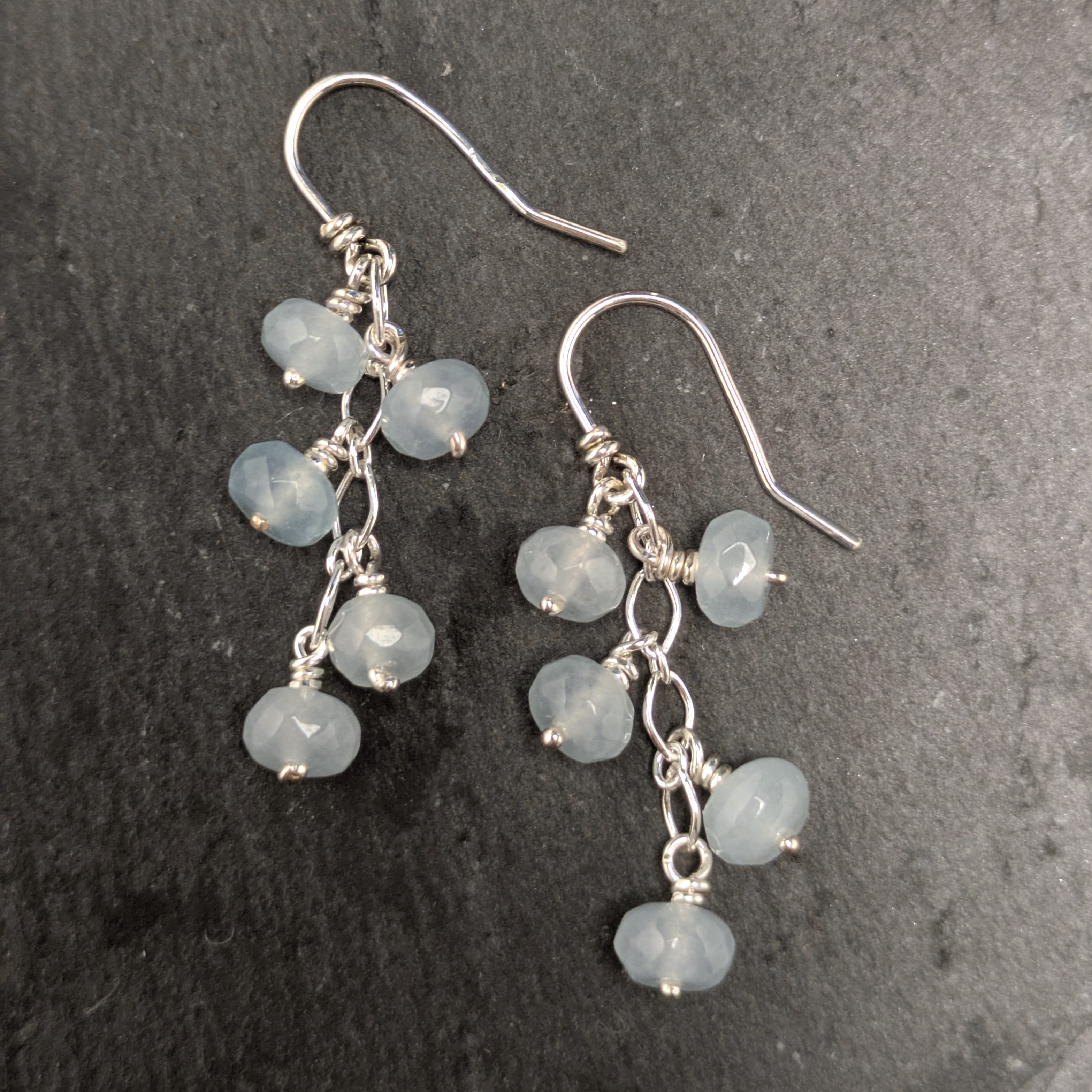 עגילי כסף בעבודת יד עם אבני אקוומרין תלויות על שרשרת עדינה