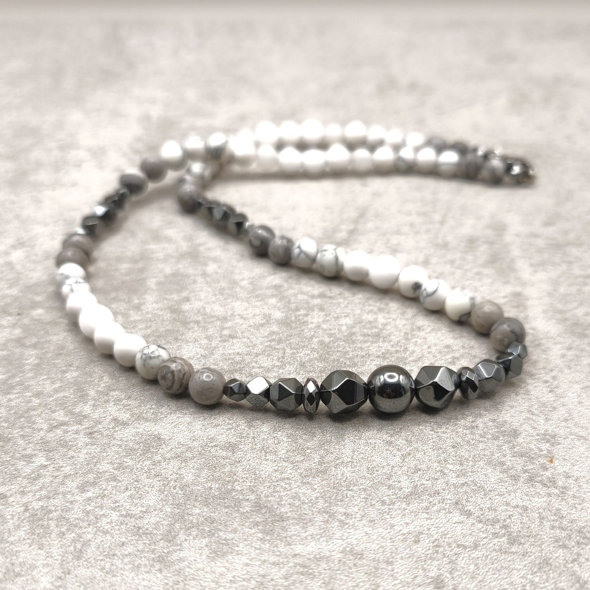 צ'וקר אבני חן עשוי בעבודת יד עם הולייט לבן, ג'ספר אפורה והמטייט שחורה, בעיצוב קצר ומודרני.