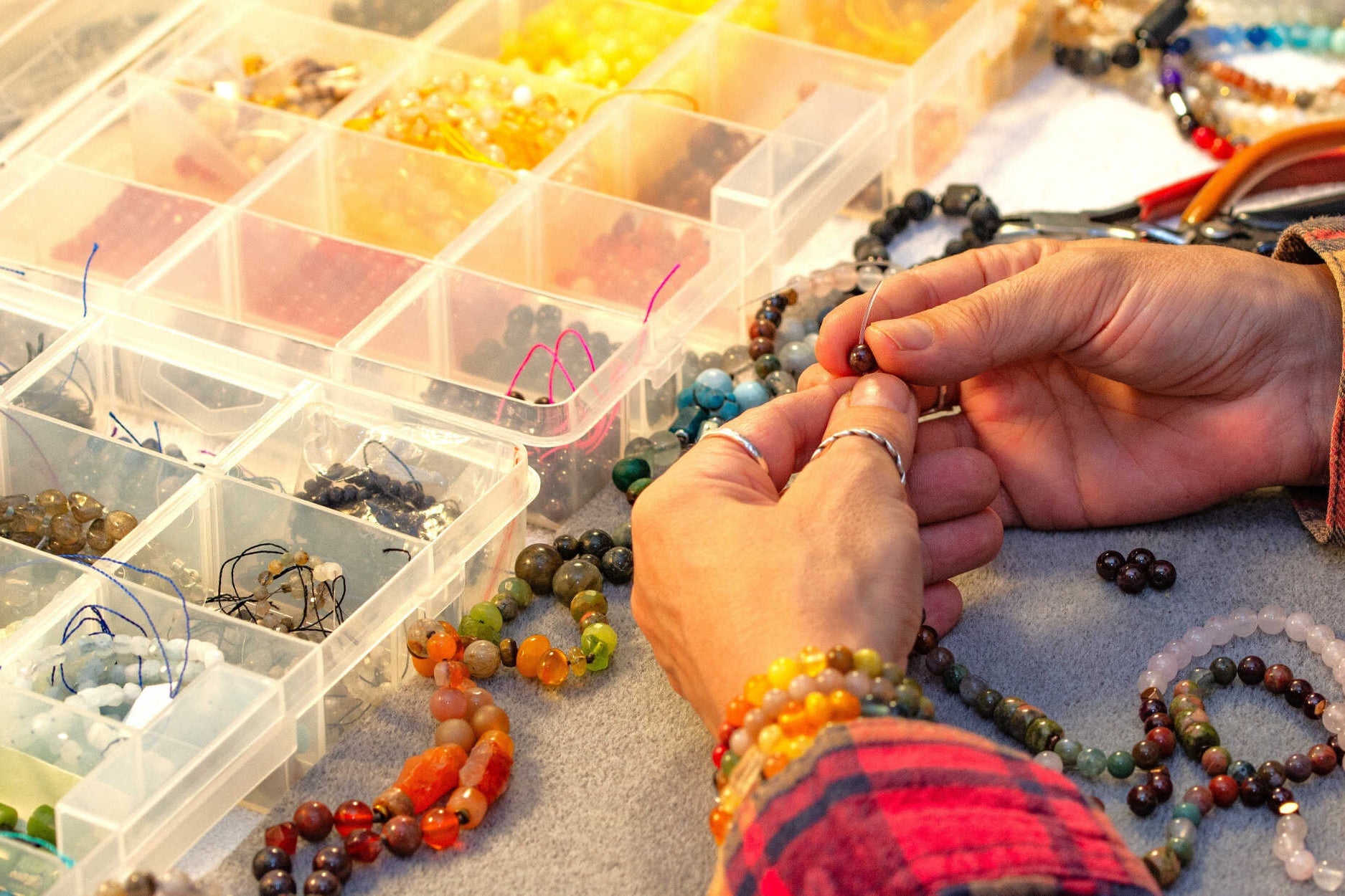 קשירת חרוזי אבני חן בעבודת יד ליצירת שרשרת מאלה