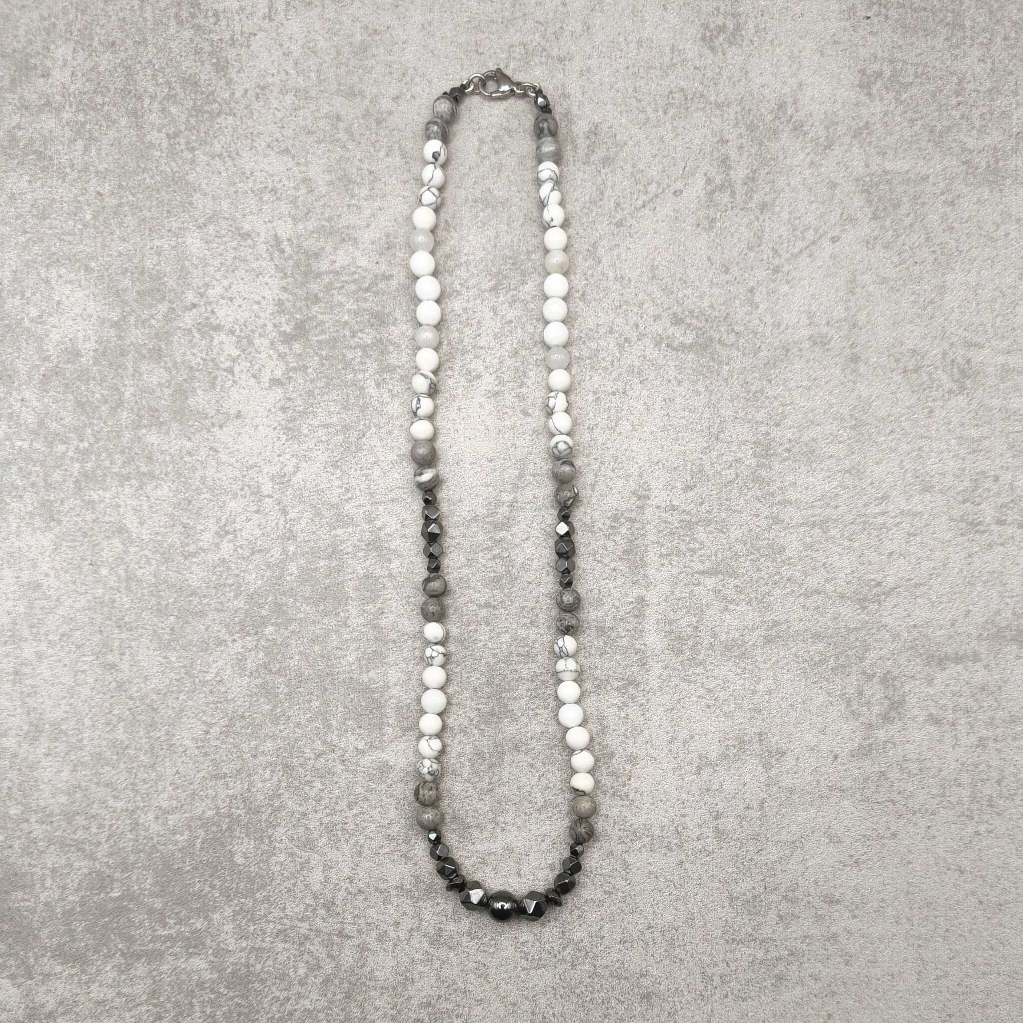 הולייט לבן מסמלת שלווה פנימית, סבלנות ובהירות מחשבה, המטייט מספקת קרקוע עוצמתי, יציבות והגנה אנרגטית, והג'ספר האפורה מחזקת איזון ויציבות רגשית.