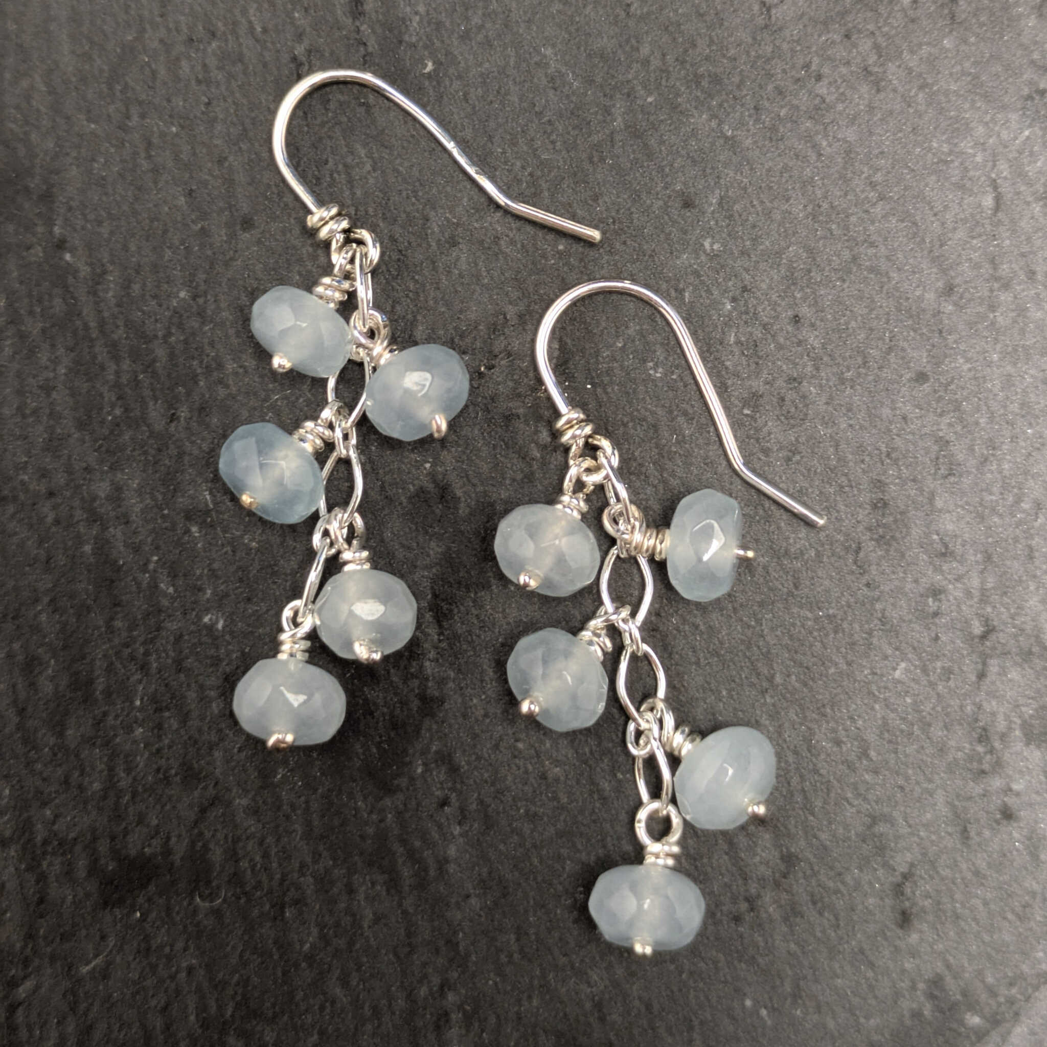 עגילי כסף בעבודת יד עם אבני אקוומרין תלויות על שרשרת עדינה