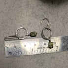 עגילי כסף בעבודת יד עם תליון פרידוט ירוק קטן התלוי על חוט כסף עד